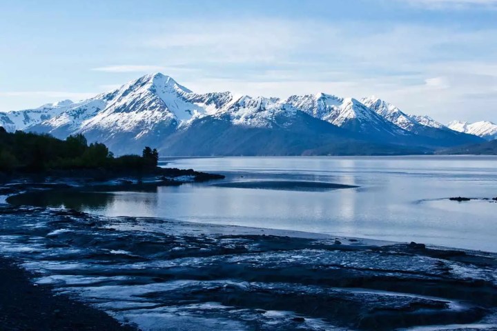 a body of water with a mountain in the snow